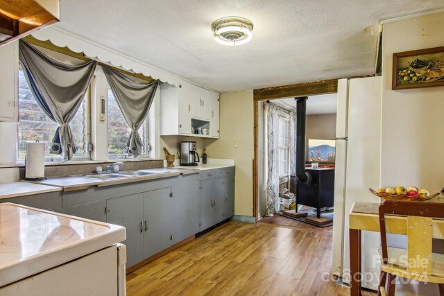 kitchen featuring gray cabinets, sink, light hardwood / wood-style flooring, and a textured ceiling