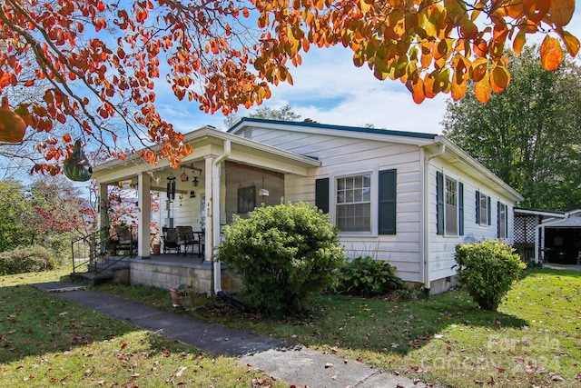 view of front of house featuring covered porch and a front lawn