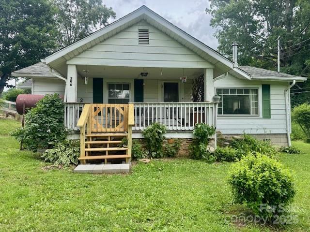 396 Will Hyatt Rd, Waynesville, NC 28786 - bungalow-style home with covered porch, a front lawn, and roof with shingles