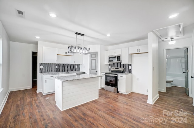 kitchen with white cabinets, dark hardwood / wood-style flooring, a center island, and stainless steel appliances