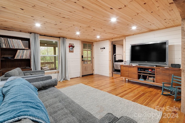 living room with wood walls, wood ceiling, and light wood-type flooring