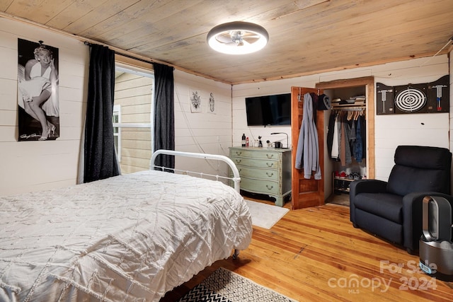 bedroom featuring wood-type flooring, a closet, and wood ceiling