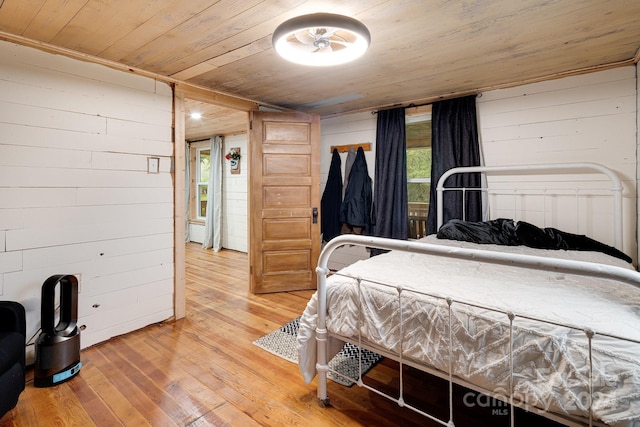 bedroom with wood walls, wooden ceiling, and wood-type flooring