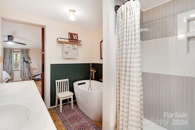 bathroom featuring shower with separate bathtub, hardwood / wood-style floors, vanity, and ceiling fan