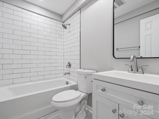 full bathroom featuring vanity, tiled shower / bath, and toilet