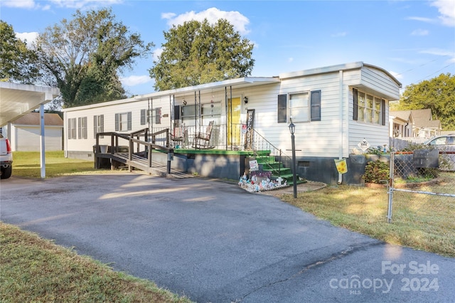 manufactured / mobile home featuring a front lawn and covered porch