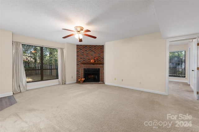 unfurnished living room with a brick fireplace, plenty of natural light, and light colored carpet