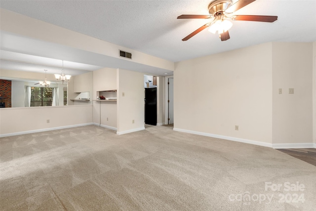 unfurnished living room featuring a textured ceiling, light colored carpet, and ceiling fan with notable chandelier