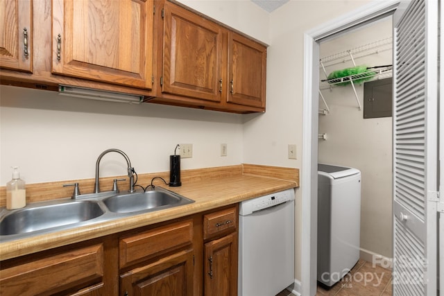 kitchen featuring tile patterned flooring, washer / dryer, white dishwasher, sink, and electric panel