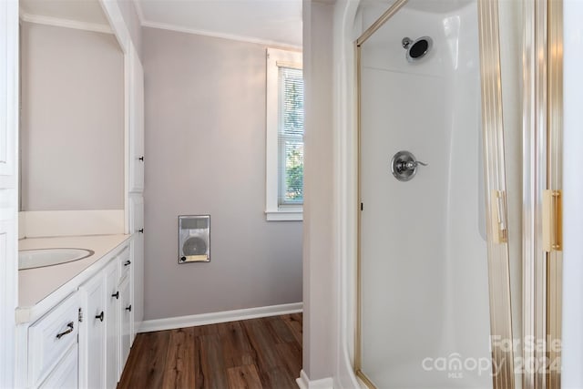 bathroom with vanity, a shower with shower door, ornamental molding, and hardwood / wood-style flooring