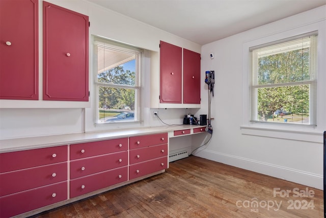 kitchen featuring wood-type flooring, baseboard heating, and plenty of natural light