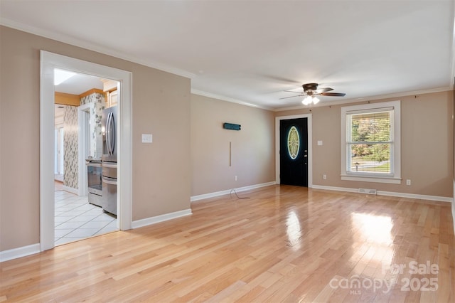 interior space featuring ceiling fan, visible vents, baseboards, light wood-type flooring, and crown molding