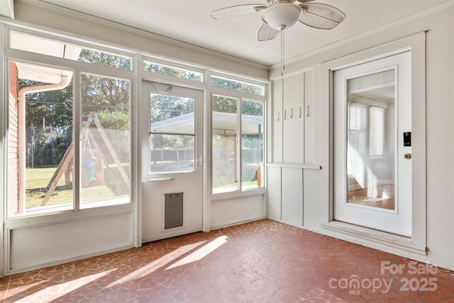 doorway with plenty of natural light, ornamental molding, and a ceiling fan