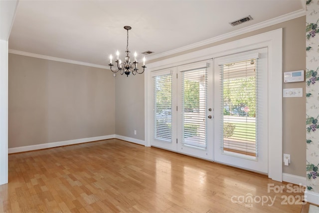 interior space with wood finished floors, visible vents, and crown molding