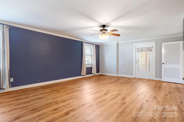 unfurnished room featuring light wood-style floors, ceiling fan, baseboards, and crown molding