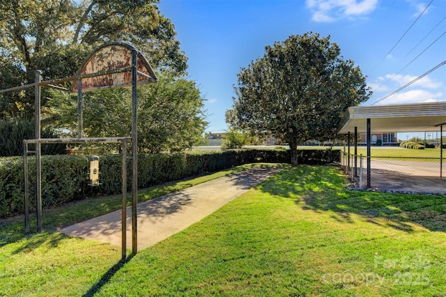 view of community featuring a lawn and fence