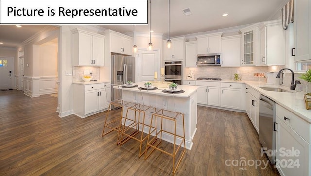kitchen with a sink, ornamental molding, white cabinets, and appliances with stainless steel finishes