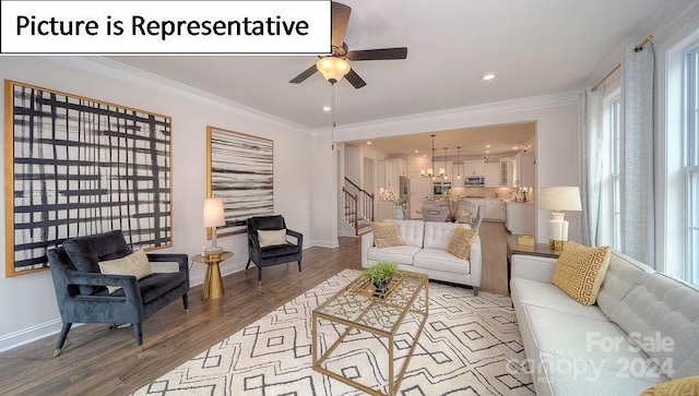 living room with baseboards, crown molding, stairs, light wood-style floors, and ceiling fan with notable chandelier