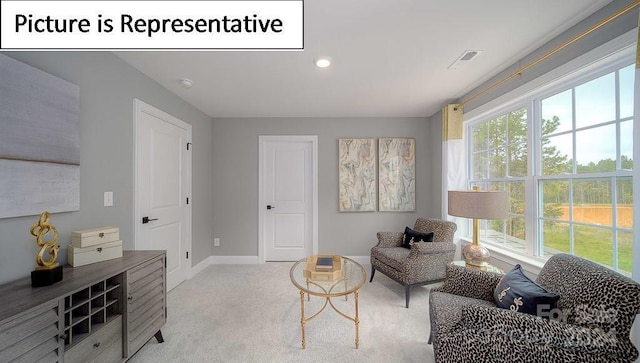 living area with visible vents, a wealth of natural light, carpet floors, and baseboards