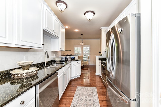 kitchen featuring white cabinets, decorative light fixtures, and stainless steel appliances