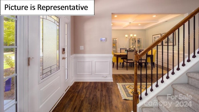 foyer featuring dark wood-style flooring, beamed ceiling, an inviting chandelier, and stairs