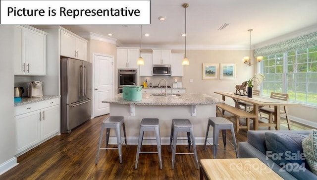 kitchen featuring a sink, a kitchen bar, crown molding, white cabinetry, and stainless steel appliances