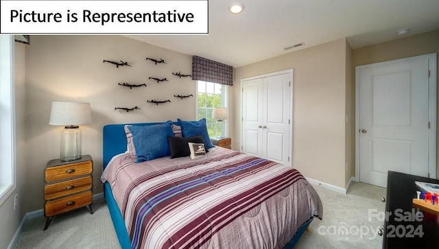 bedroom featuring a closet, light colored carpet, baseboards, and visible vents