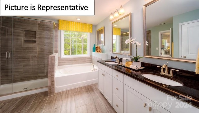bathroom with a shower stall, a garden tub, and a sink
