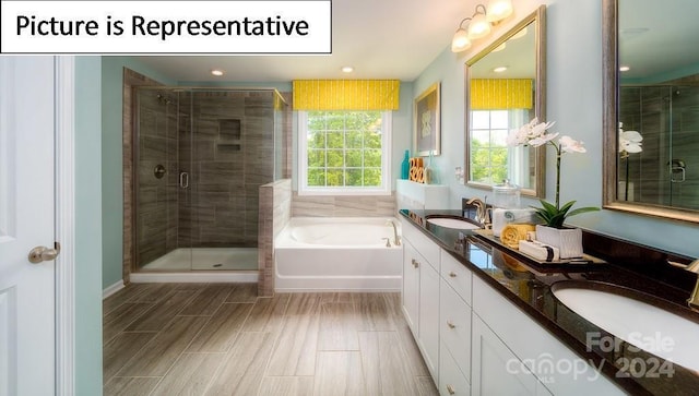 bathroom featuring double vanity, a garden tub, a sink, and a stall shower