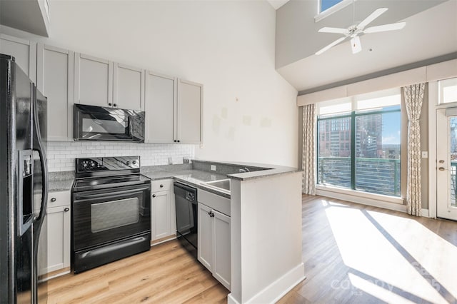 kitchen with ceiling fan, sink, tasteful backsplash, light hardwood / wood-style flooring, and black appliances