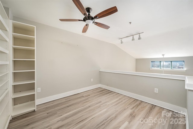 spare room with ceiling fan, light hardwood / wood-style floors, lofted ceiling, and track lighting