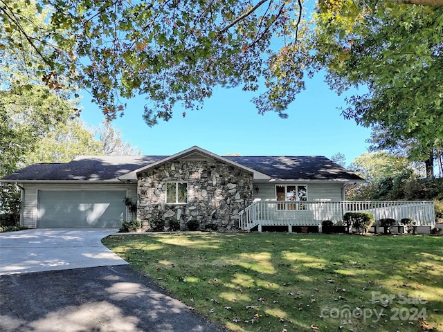 single story home with a garage, a front lawn, and a deck