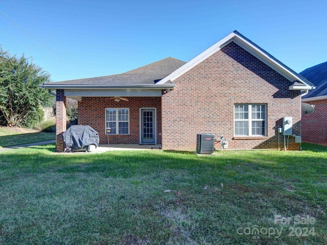 rear view of house featuring a yard, cooling unit, and a patio