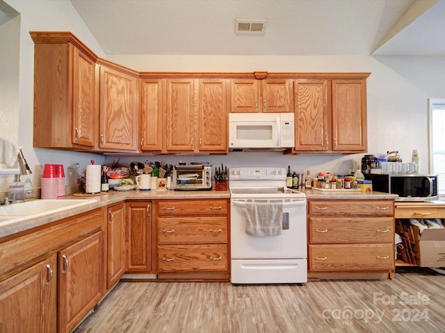 kitchen featuring sink, light hardwood / wood-style flooring, and white appliances