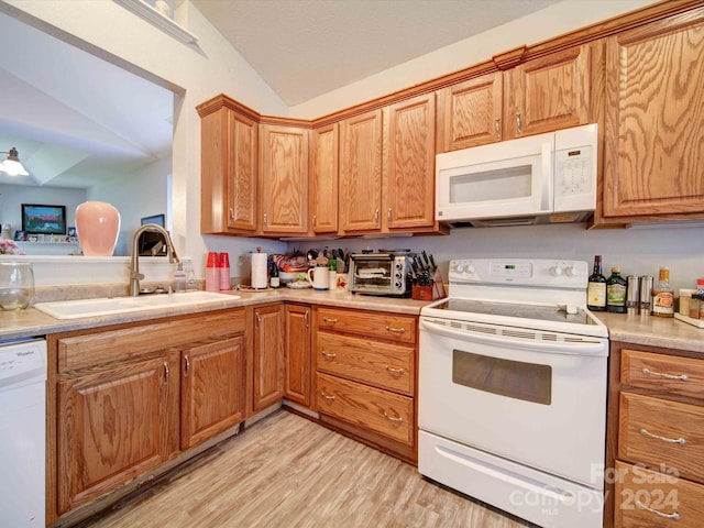 kitchen featuring lofted ceiling, white appliances, sink, light hardwood / wood-style floors, and ceiling fan