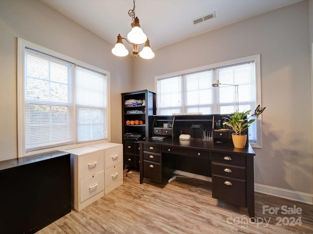 office space with an inviting chandelier and light wood-type flooring