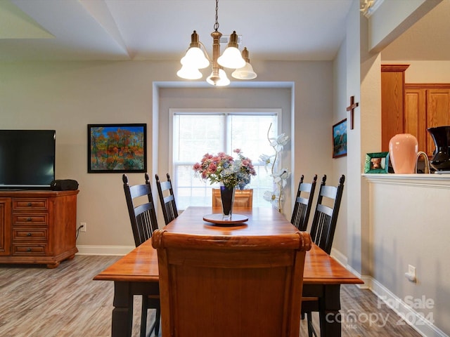 dining space featuring light hardwood / wood-style floors and an inviting chandelier