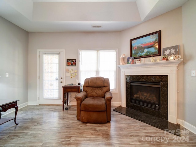 living area with a premium fireplace and hardwood / wood-style flooring