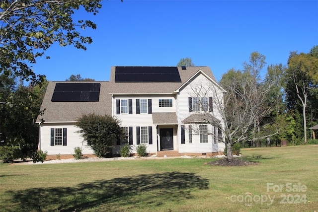 view of front of home featuring a front yard and solar panels