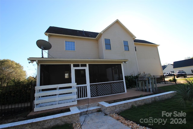 back of property featuring a sunroom and a patio area