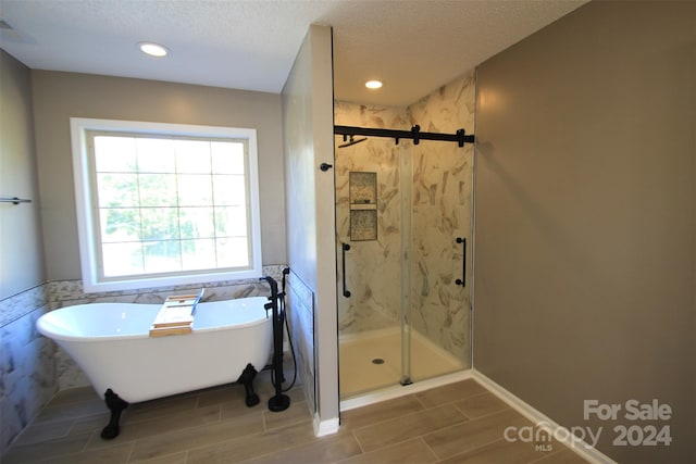 bathroom featuring a textured ceiling and plus walk in shower