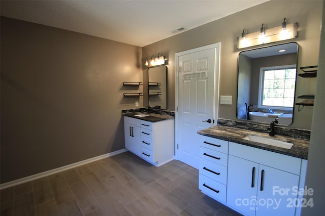 bathroom with hardwood / wood-style floors, vanity, and a bathing tub