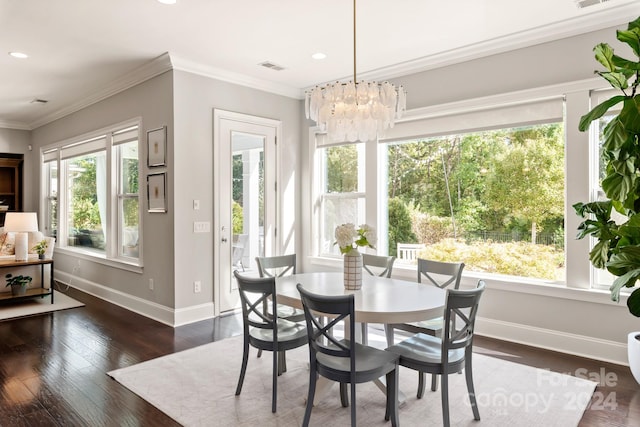 dining room featuring a notable chandelier, dark wood-type flooring, plenty of natural light, and crown molding