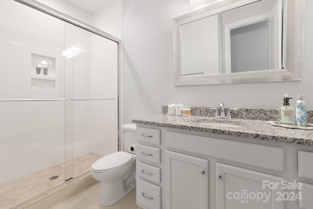 bathroom featuring vanity, toilet, and an enclosed shower