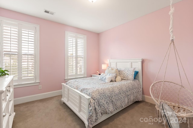 bedroom featuring multiple windows and light colored carpet