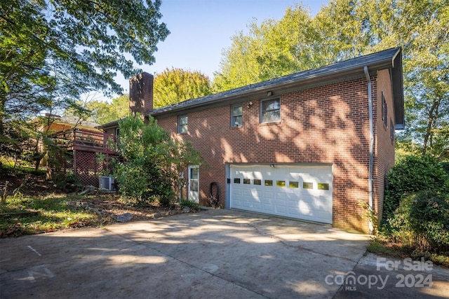 view of front of property featuring cooling unit and a garage