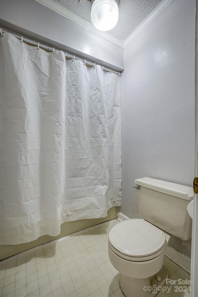 bathroom with tile patterned floors, ornamental molding, a textured ceiling, and toilet