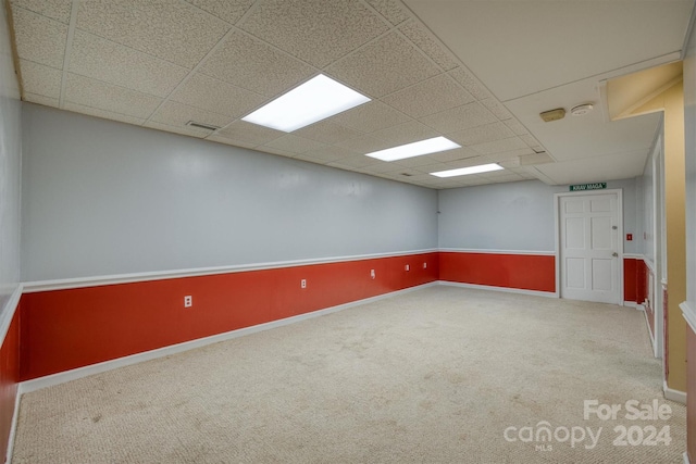 carpeted spare room featuring a paneled ceiling