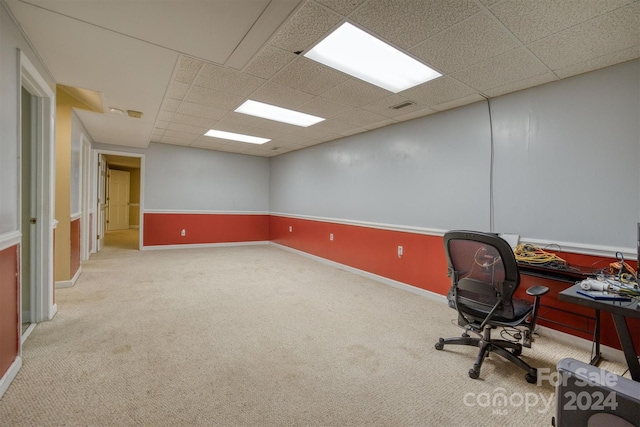 carpeted home office with a drop ceiling