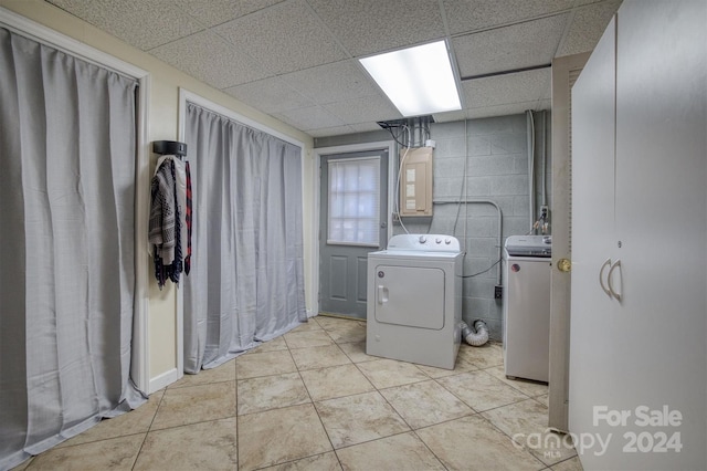 washroom featuring tile walls, separate washer and dryer, and light tile patterned floors